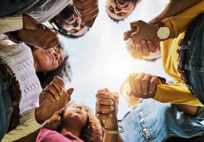 studenten houden elkaars handen vast in een groepsgesprek